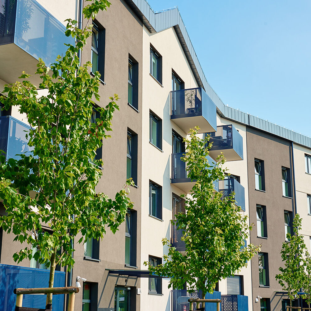 Modern apartment building with balconies and green trees on sunny day. Residential complex in Wroclaw, Poland. Mortgage in real estate